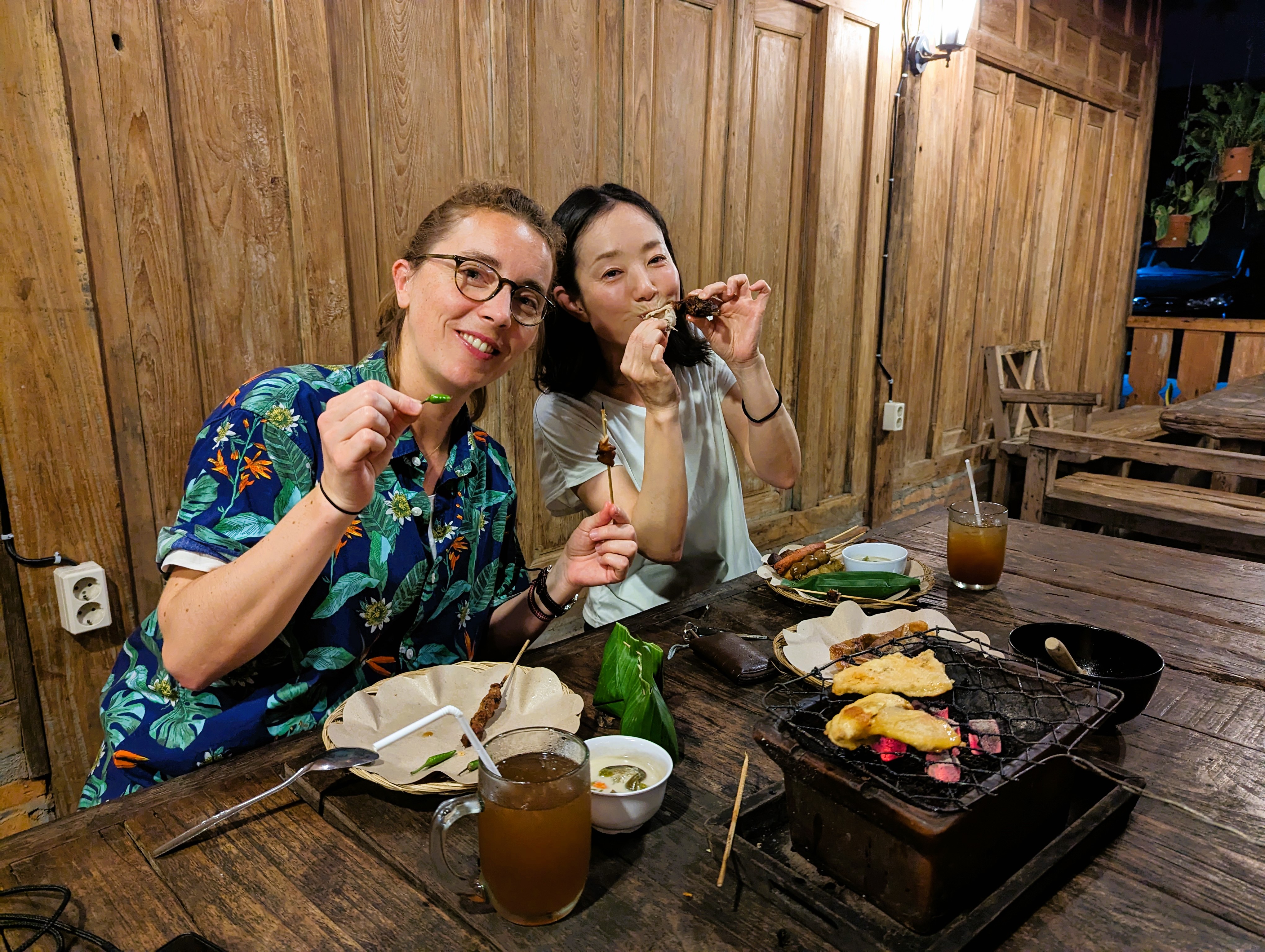 Isabel of Elrha and Ikue of ADRRN are eating traditional grilled food